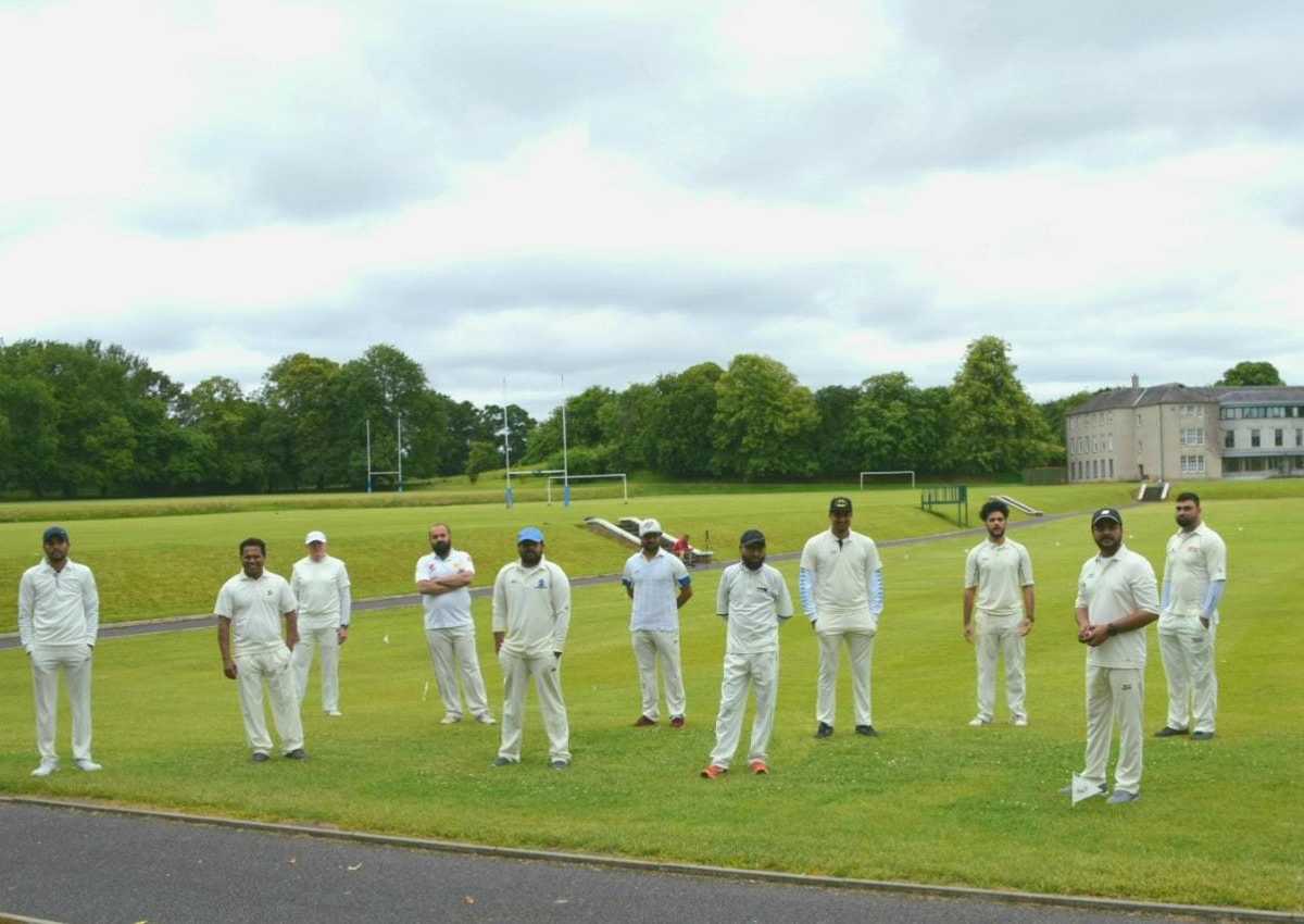 Members dressed in traditional cricket attire enjoying a lively match at Dundalk Cricket Club